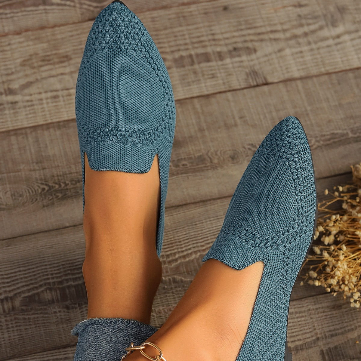Blue breathable pointed-toe knit flats with a textured pattern.