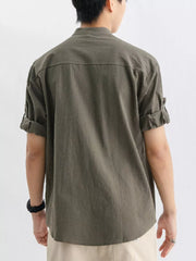 Relaxed fit button-up shirt in dark green with rolled sleeves and a chest pocket.