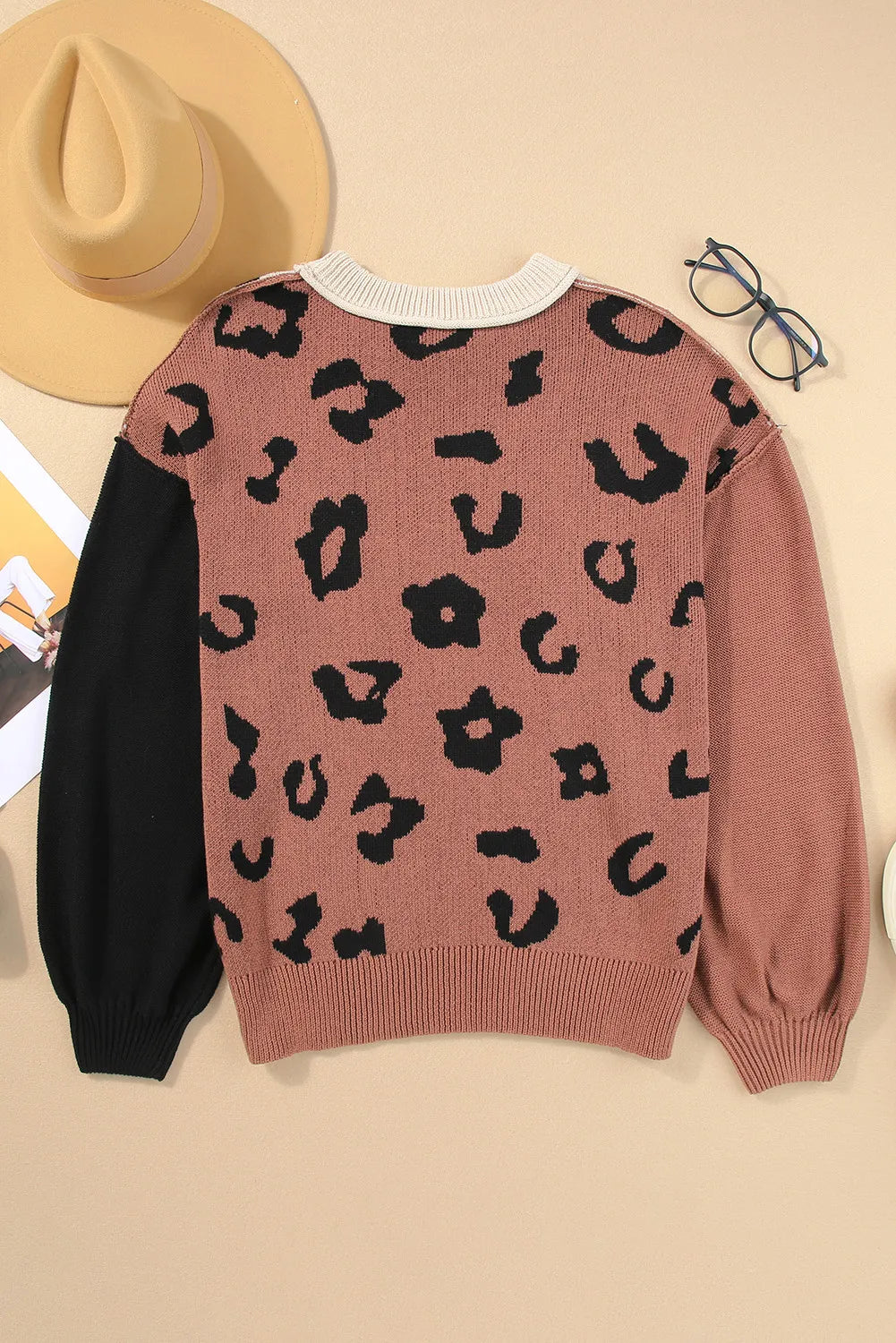 Colorblock leopard print knit sweater with black sleeves and crew neck.