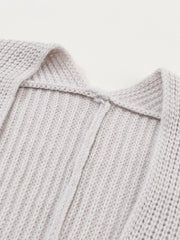 Light gray acrylic knit cardigan showing neckline detail and ribbed texture.