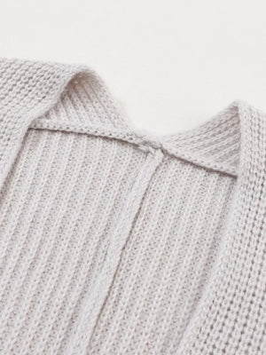 Light gray acrylic knit cardigan showing neckline detail and ribbed texture.