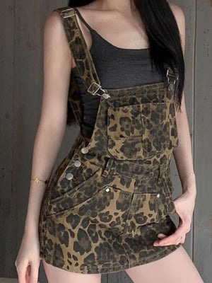 Denim overall dress with leopard print, adjustable straps, buckle detail, and buttoned sides.
