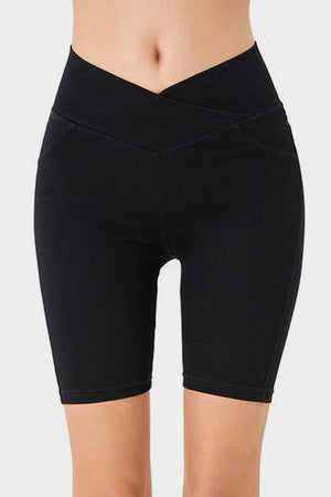 Black denim bermuda shorts with a crisscross waistband and asymmetrical detail.