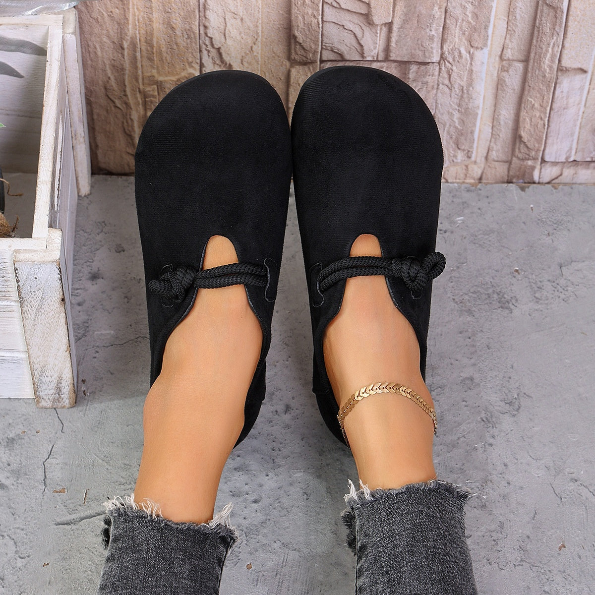 Black matte fabric round toe flats with cord detail and cutouts.
