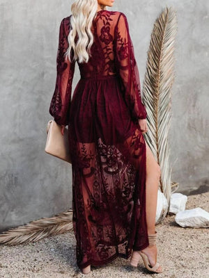 Burgundy floral lace maxi dress with long sleeves, high slit, and sheer overlay.