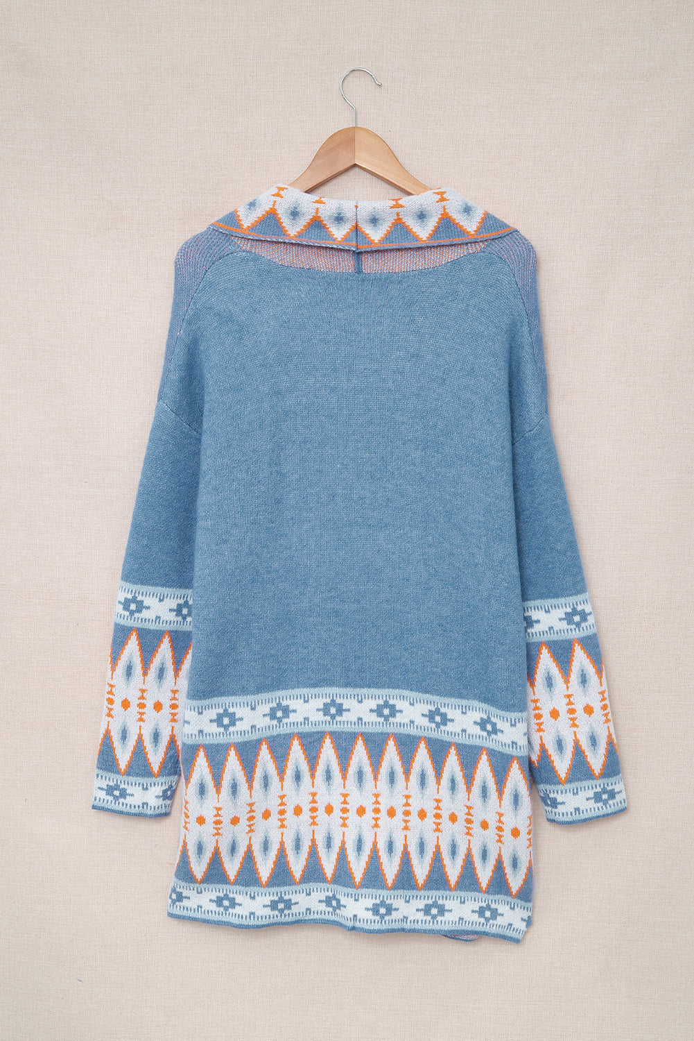 Blue knit cardigan with geometric trim on collar and sleeves.
