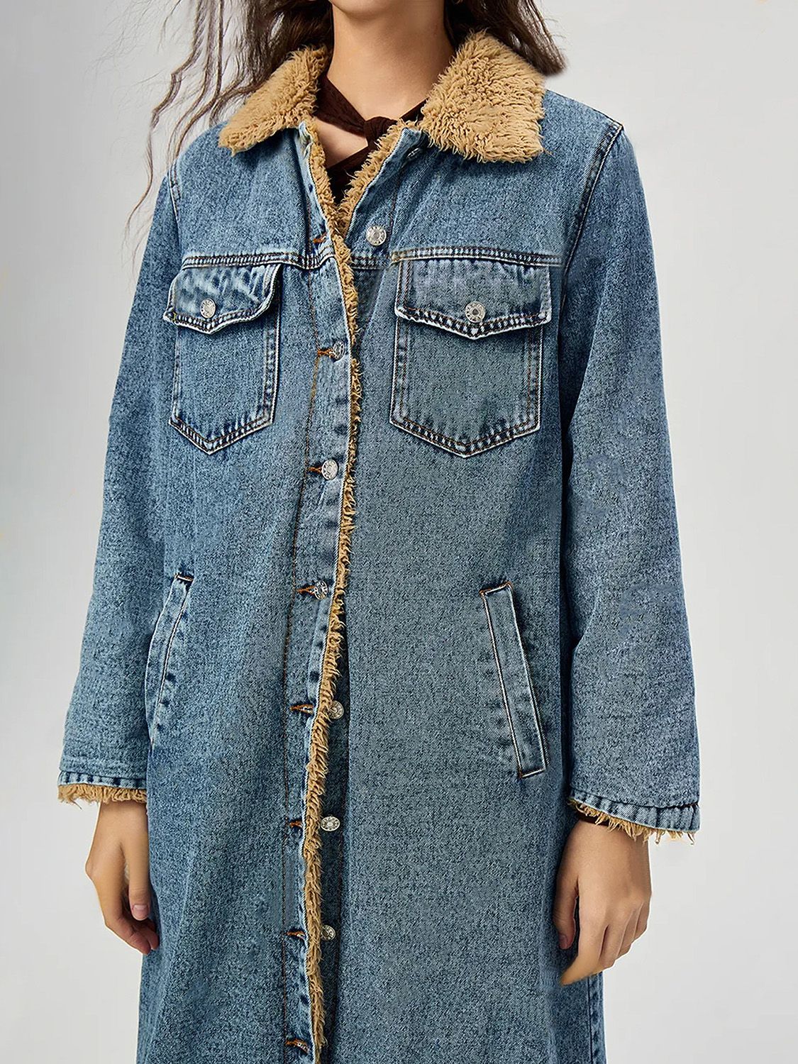 Denim maxi coat in medium wash with shearling trim and button closure.