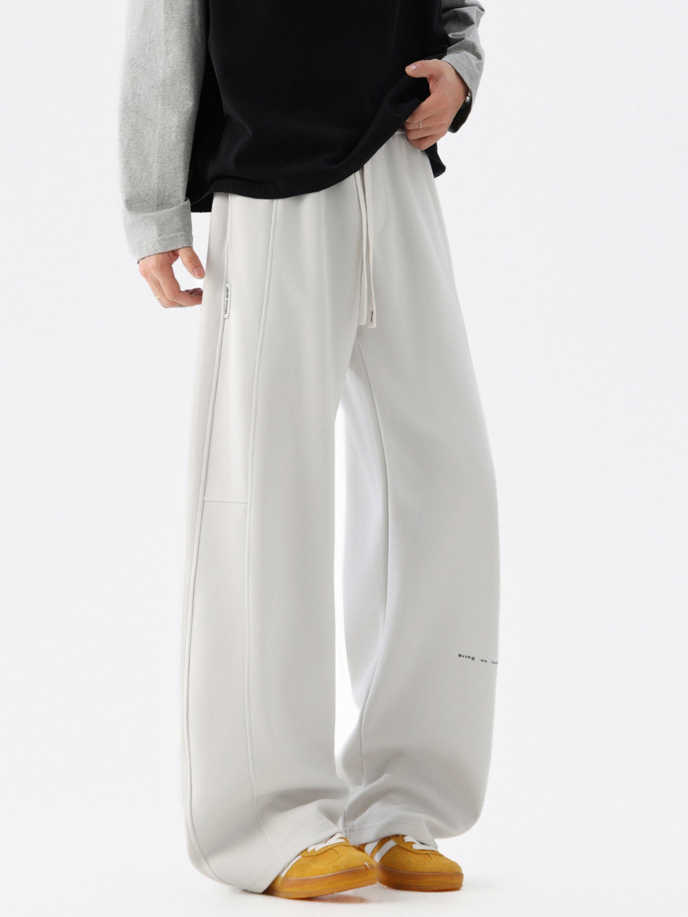 Light gray casual drawstring pants with a relaxed fit and subtle text detail.
