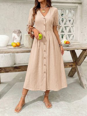 Tan button-down midi dress with v-neck, short sleeves with tie details, and a-line skirt.
