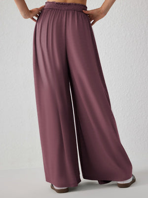 Drape-front wide-leg jersey trousers in Moonlit Mauve with a smocked waistband.