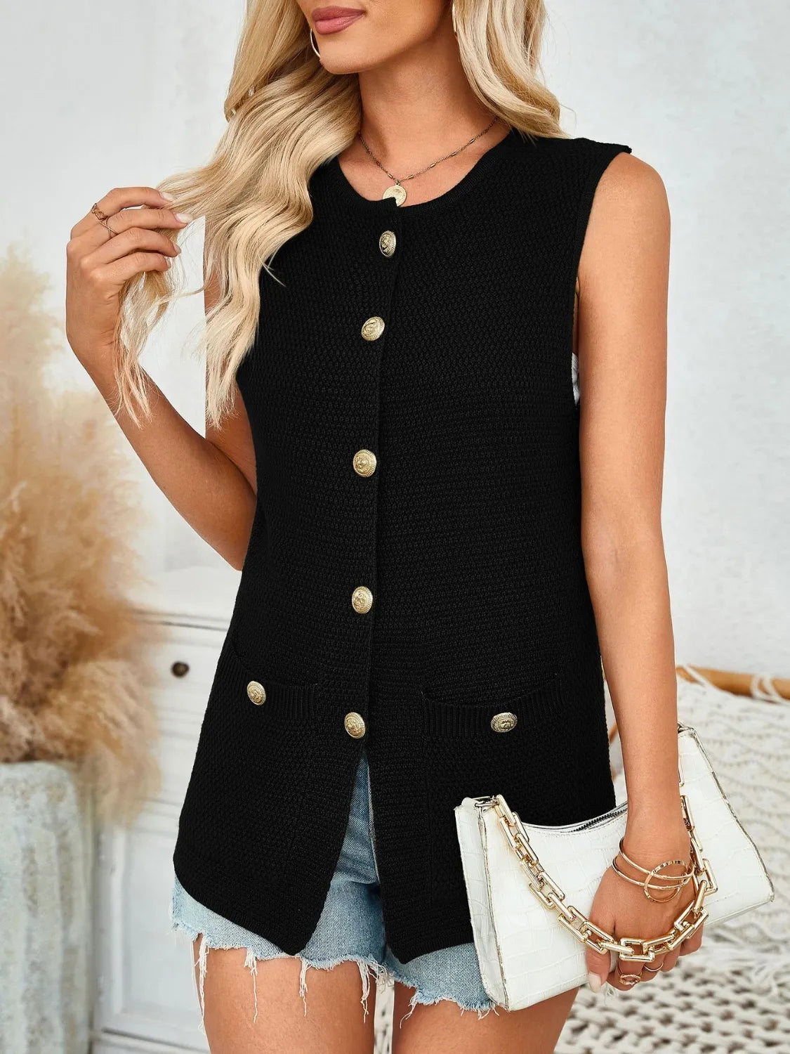 Black buttoned knit vest with gold buttons and pocket details