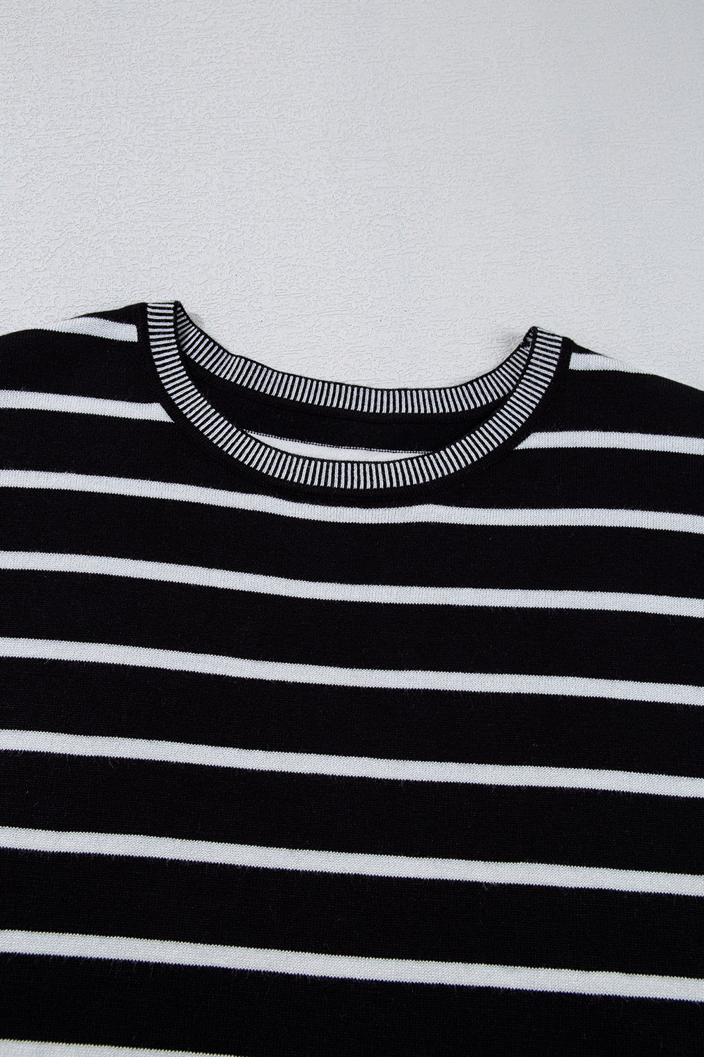 Black and white striped knit tee with contrast ribbed neckline and cuffs.