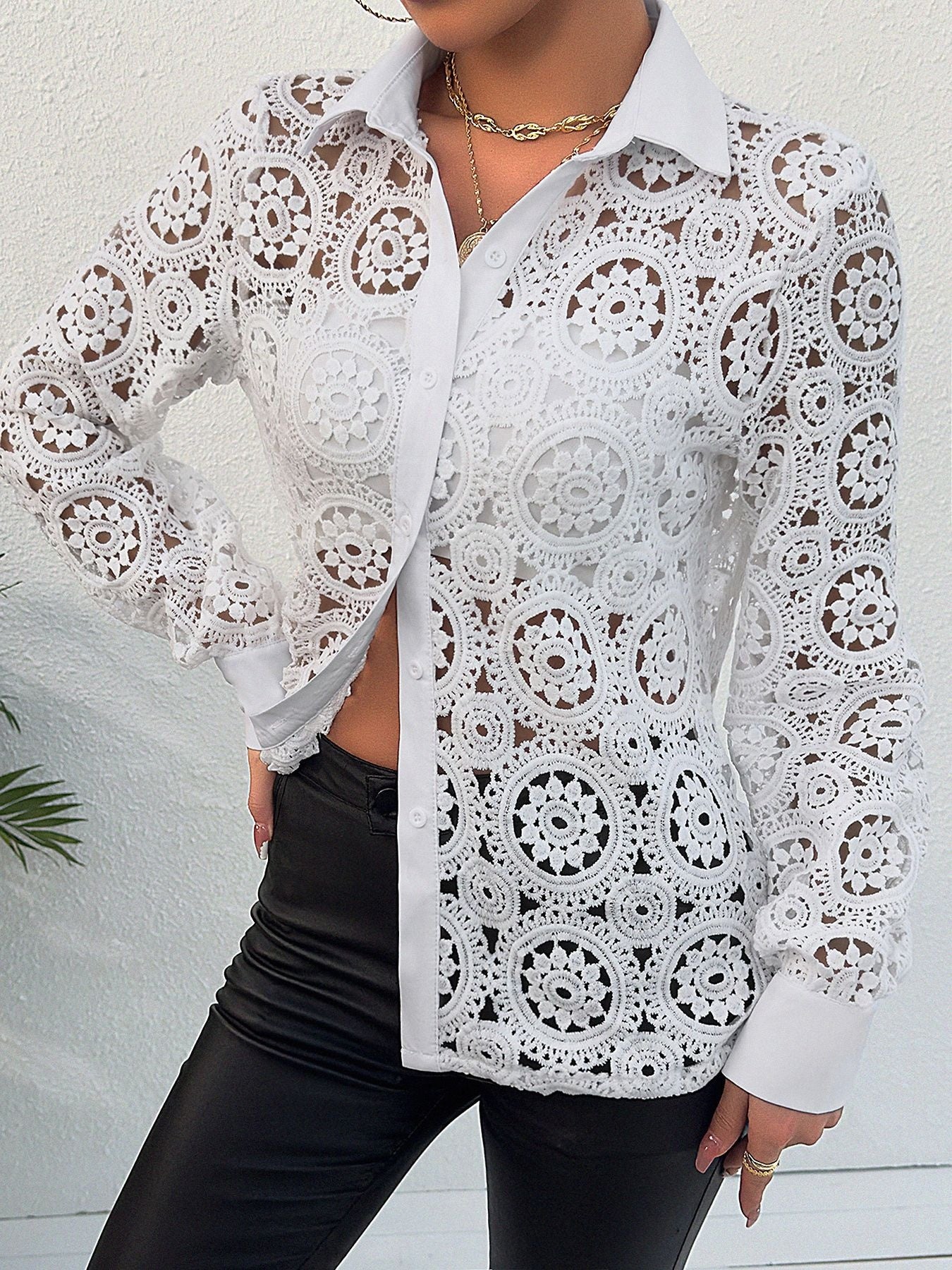 White lace cutout button-up shirt with classic collar and long sleeves.