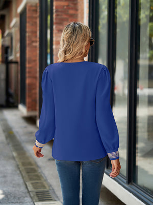Royal blue blouson sleeve top with embroidered trim cuffs and puff sleeves.