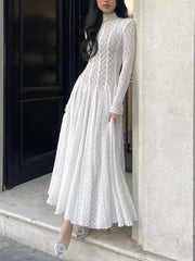 White lace maxi dress with mock neck, long sleeves, and full skirt.