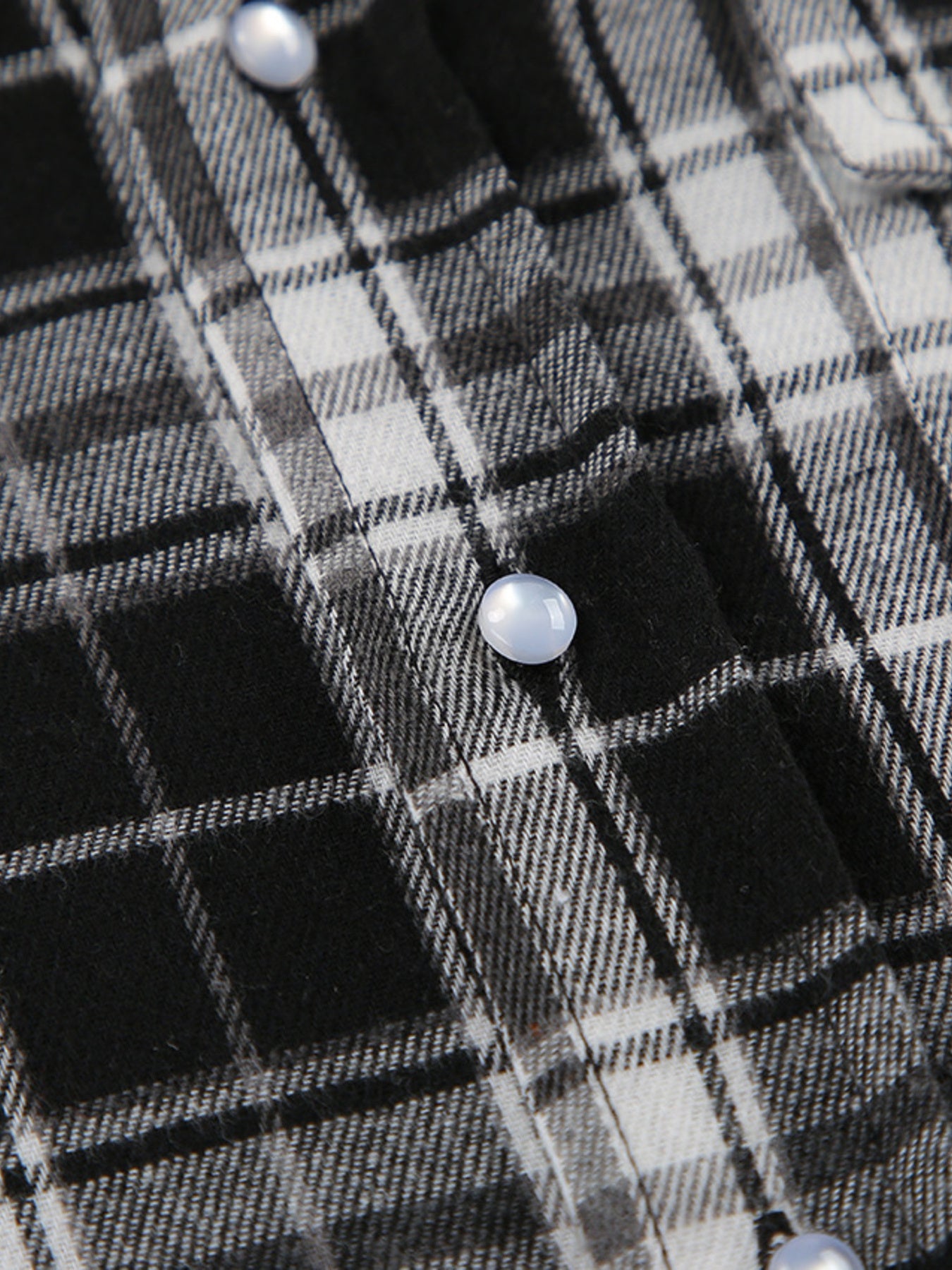 Oversized button-up shirt in black and white plaid cotton with pearl buttons.