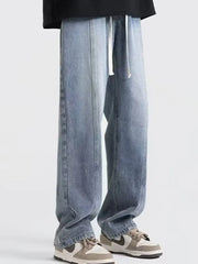 Men's blue oversized fit jeans with drawstring and seam detail.