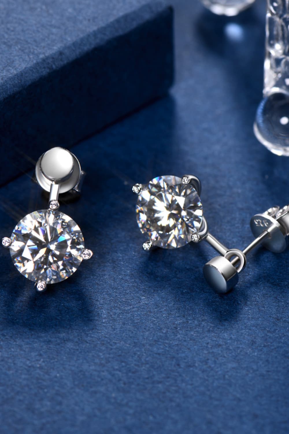 Silver moissanite stud and drop earrings with round-cut stones.