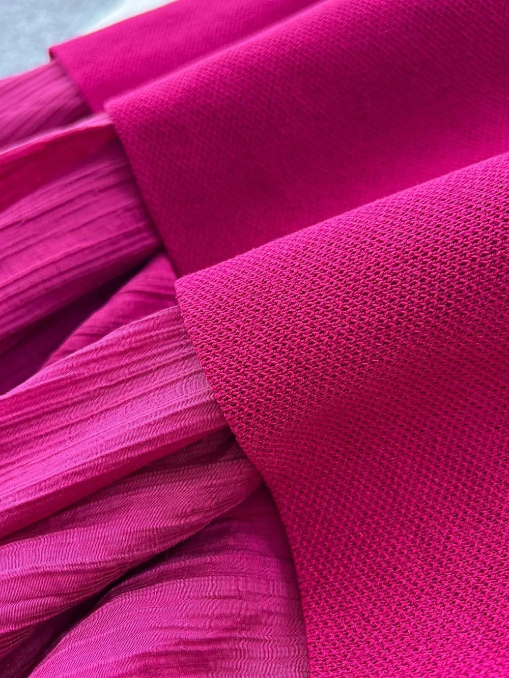 Sheer two-piece set in magenta with textured fabric and subtle button details.