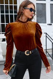 Brown velvet blouse with gathered puff sleeves and mock neck.