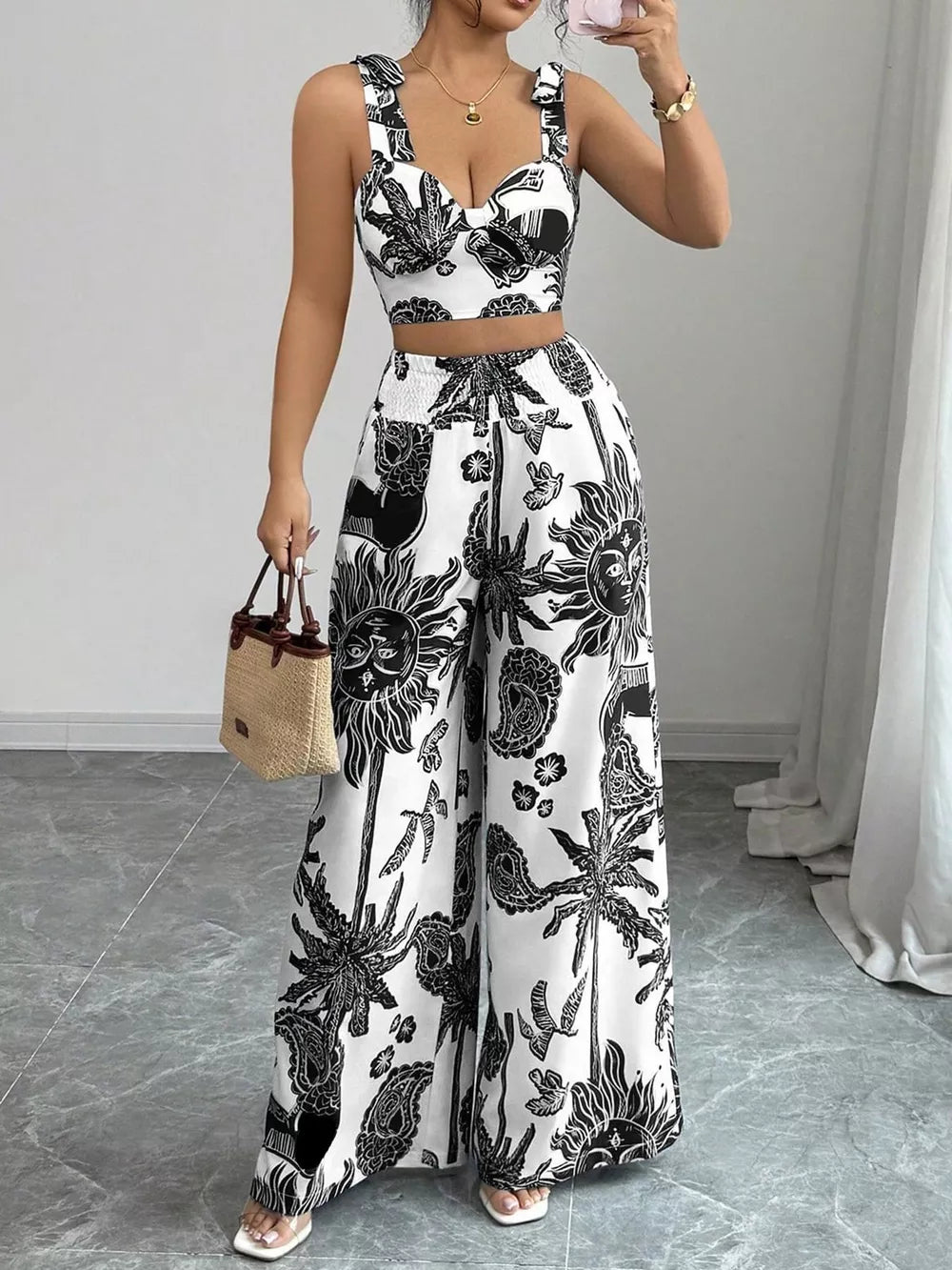 Black and white tropical print crop top and wide-leg pants set with tie straps.