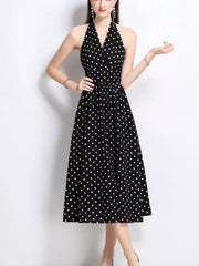 Black polka dot halter midi dress with a V-neck and gathered waist.