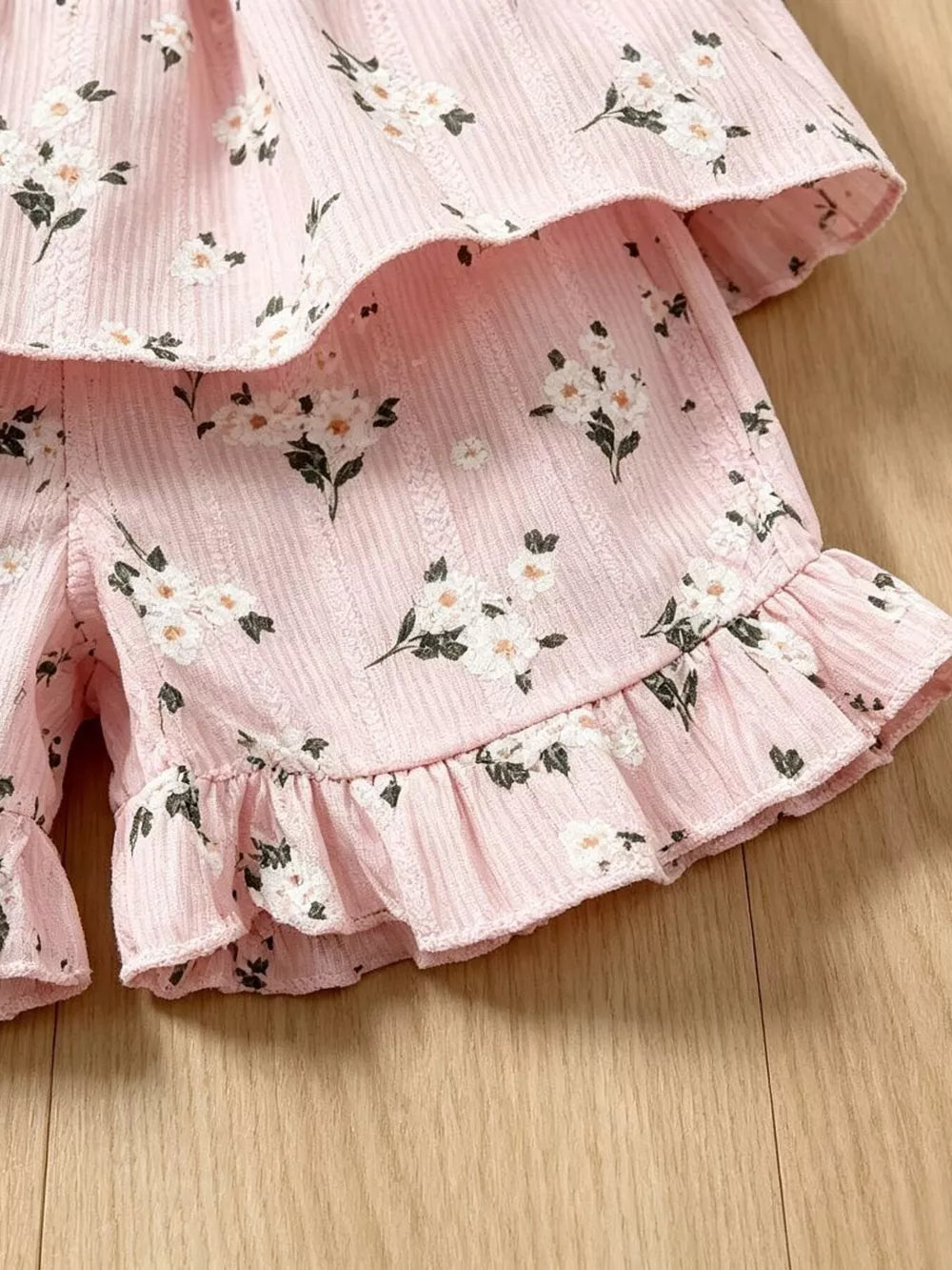 Pink floral ruffle baby set with tiered top and ruffled hem shorts.