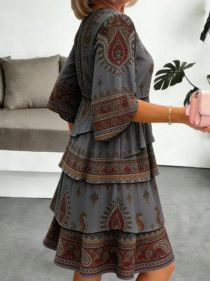 Paisley print mini dress in dark gray with tiered ruffles and bell sleeves.