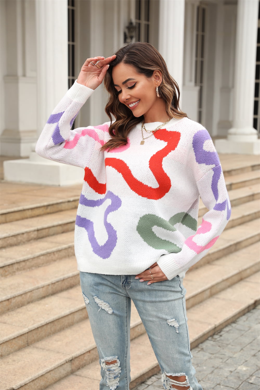 White crewneck sweater with abstract swirl pattern in red, purple, pink, and green.