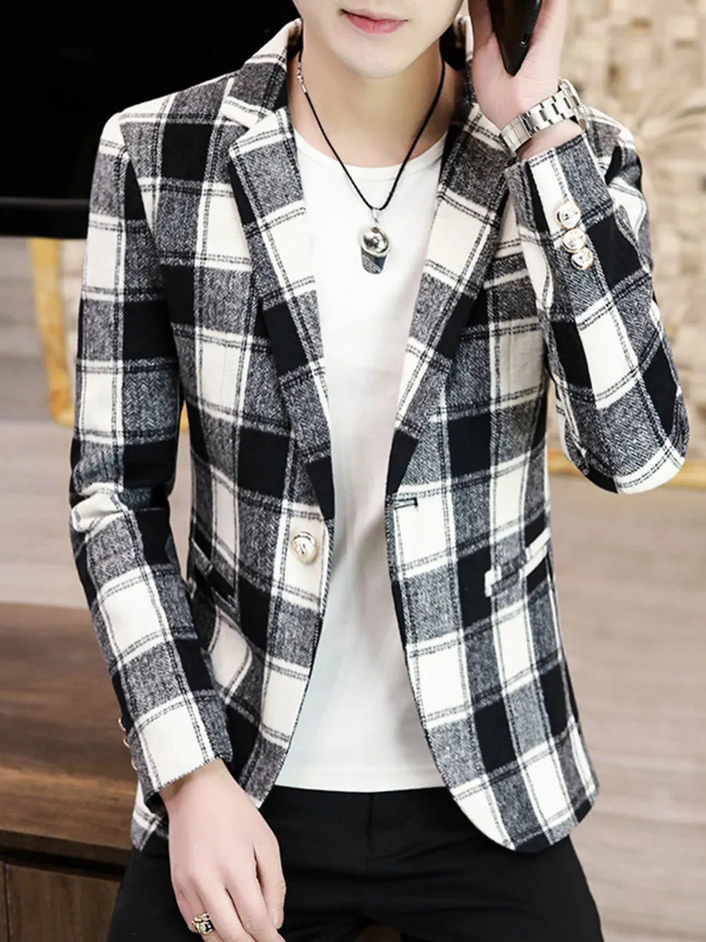 Men's black and white plaid blazer with button closure and detailed cuffs.