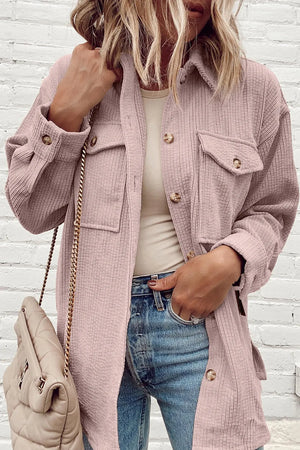 Dusty pink corduroy oversized utility jacket with button pockets and cuffs.