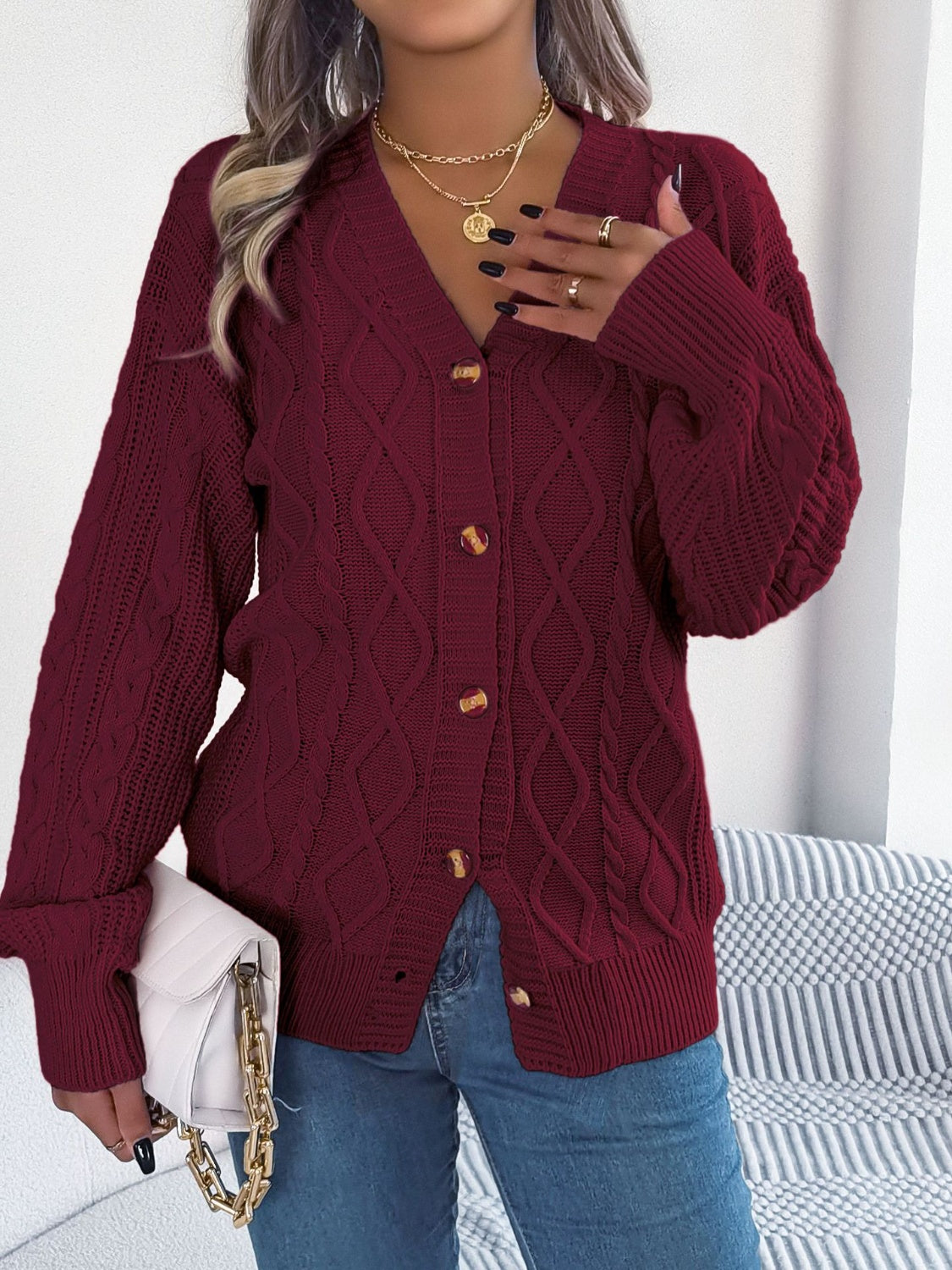 Burgundy cable knit cardigan with balloon sleeves and button front.