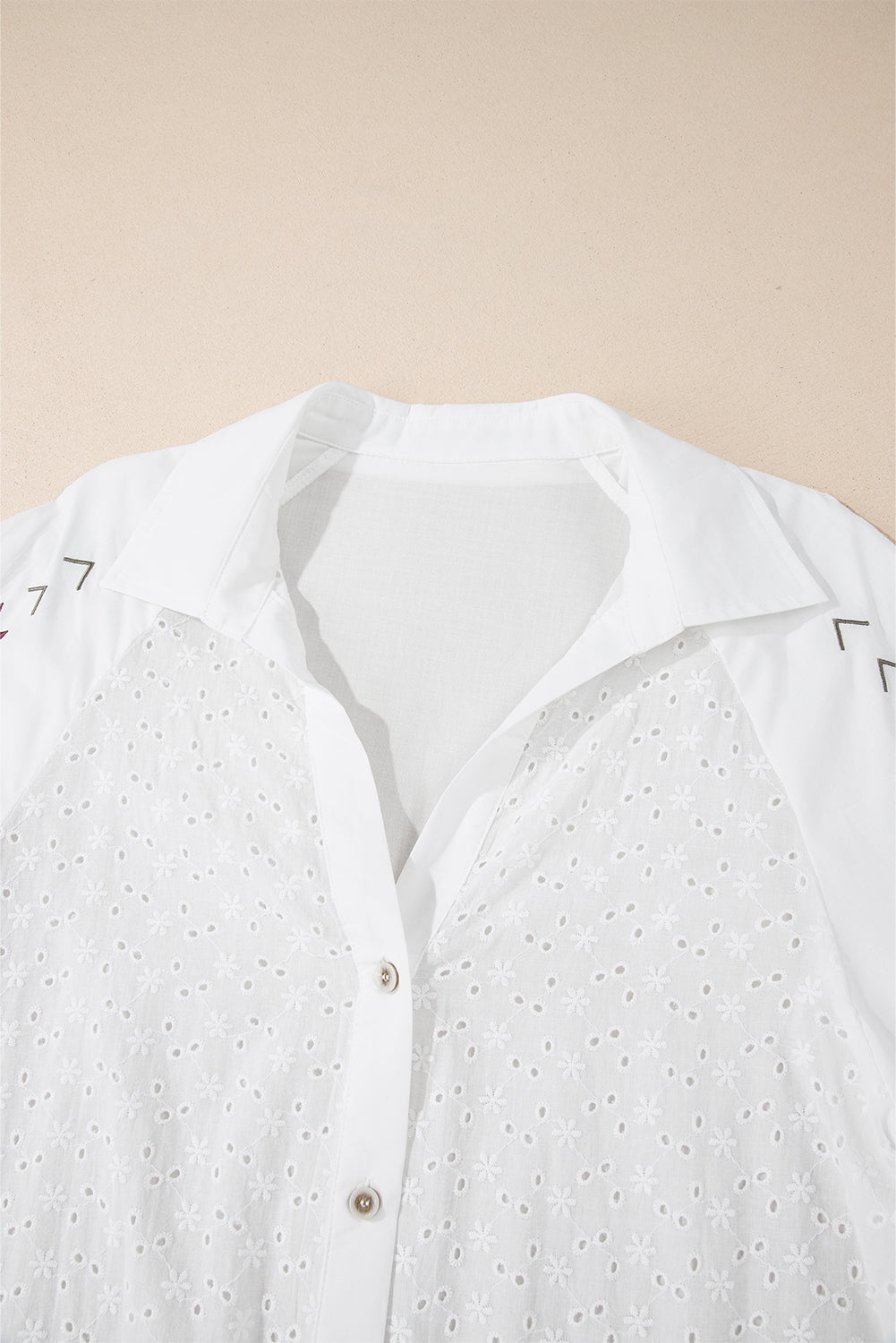 White eyelet blouse with embroidered detail and poet sleeves.