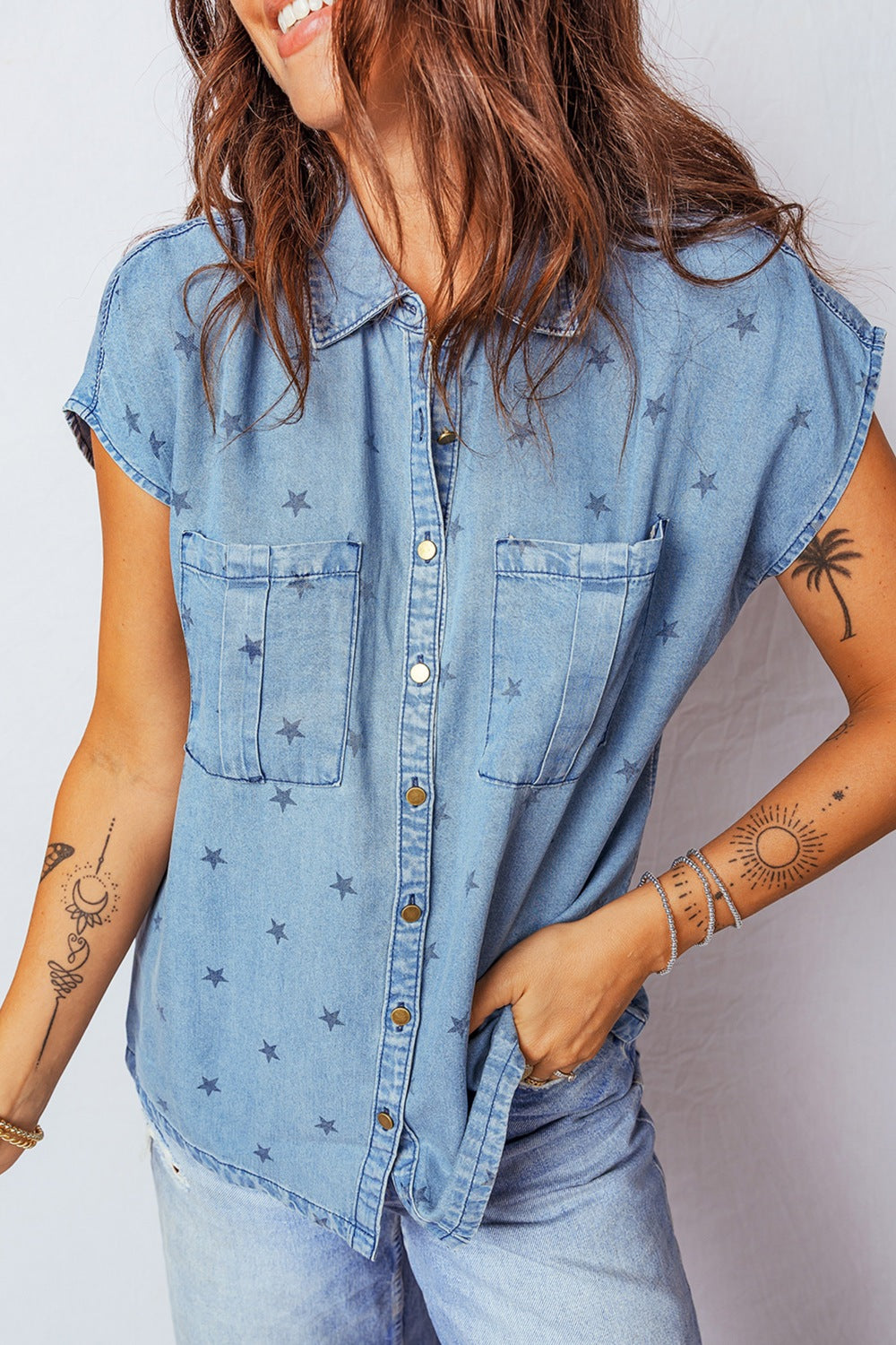Denim shirt with star print, short sleeves, button-down front, and two chest pockets.