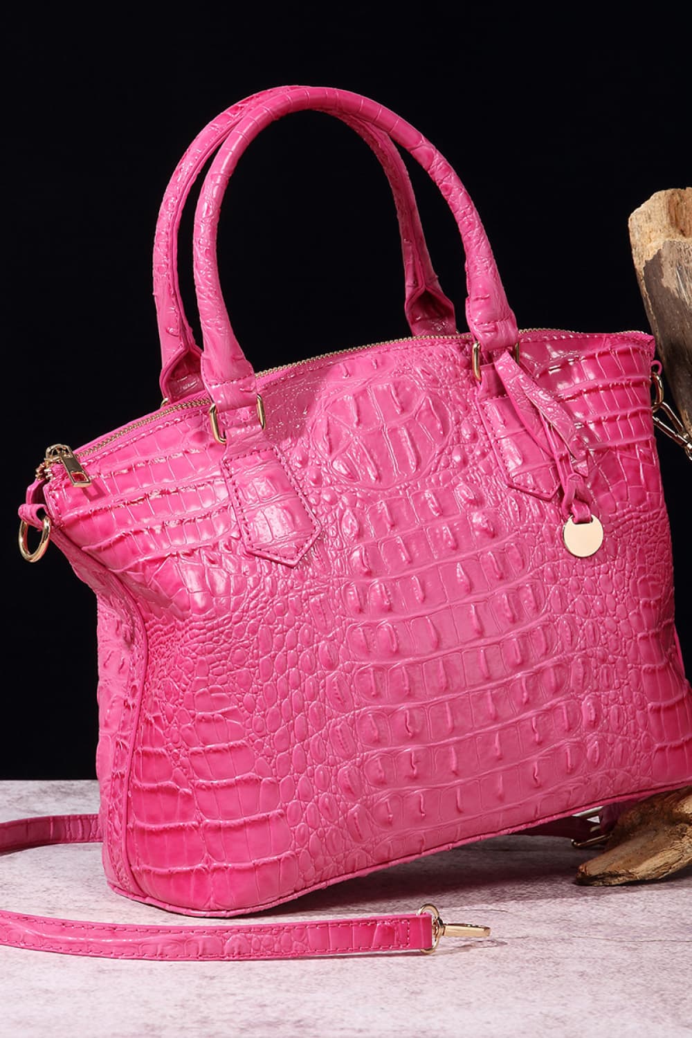 Fuchsia pink crocodile embossed satchel bag with top handles and gold hardware.