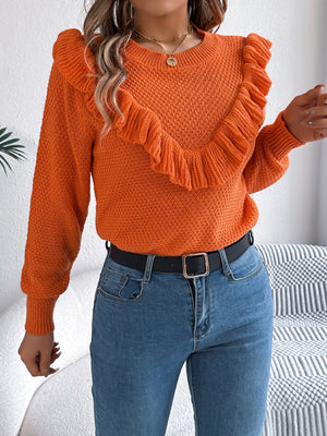 Orange textured knit sweater with ruffle yoke detail and crew neck.