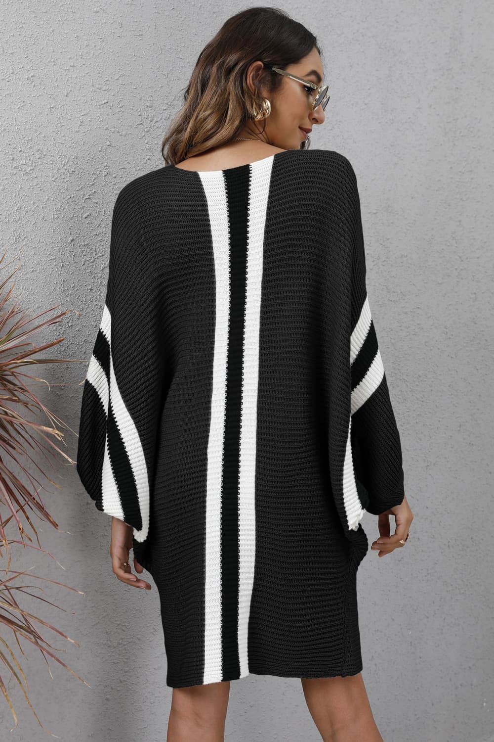 Black oversized knit cocoon dress with white stripe details on front and sleeves.