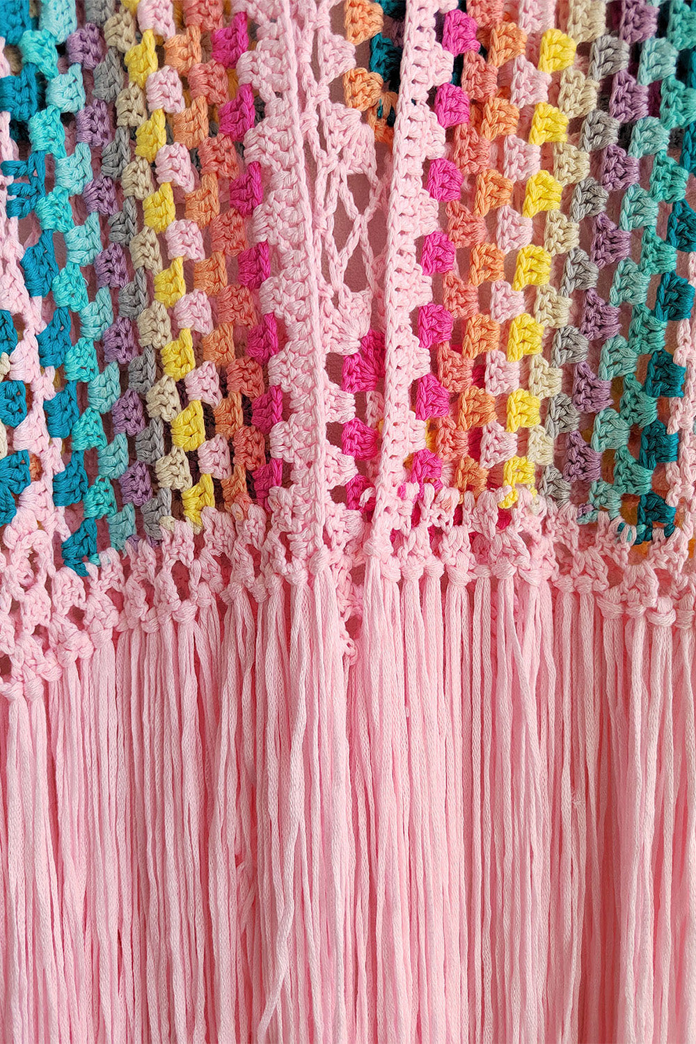 Granny square crochet duster in blush pink with multicolor squares and fringe detail.