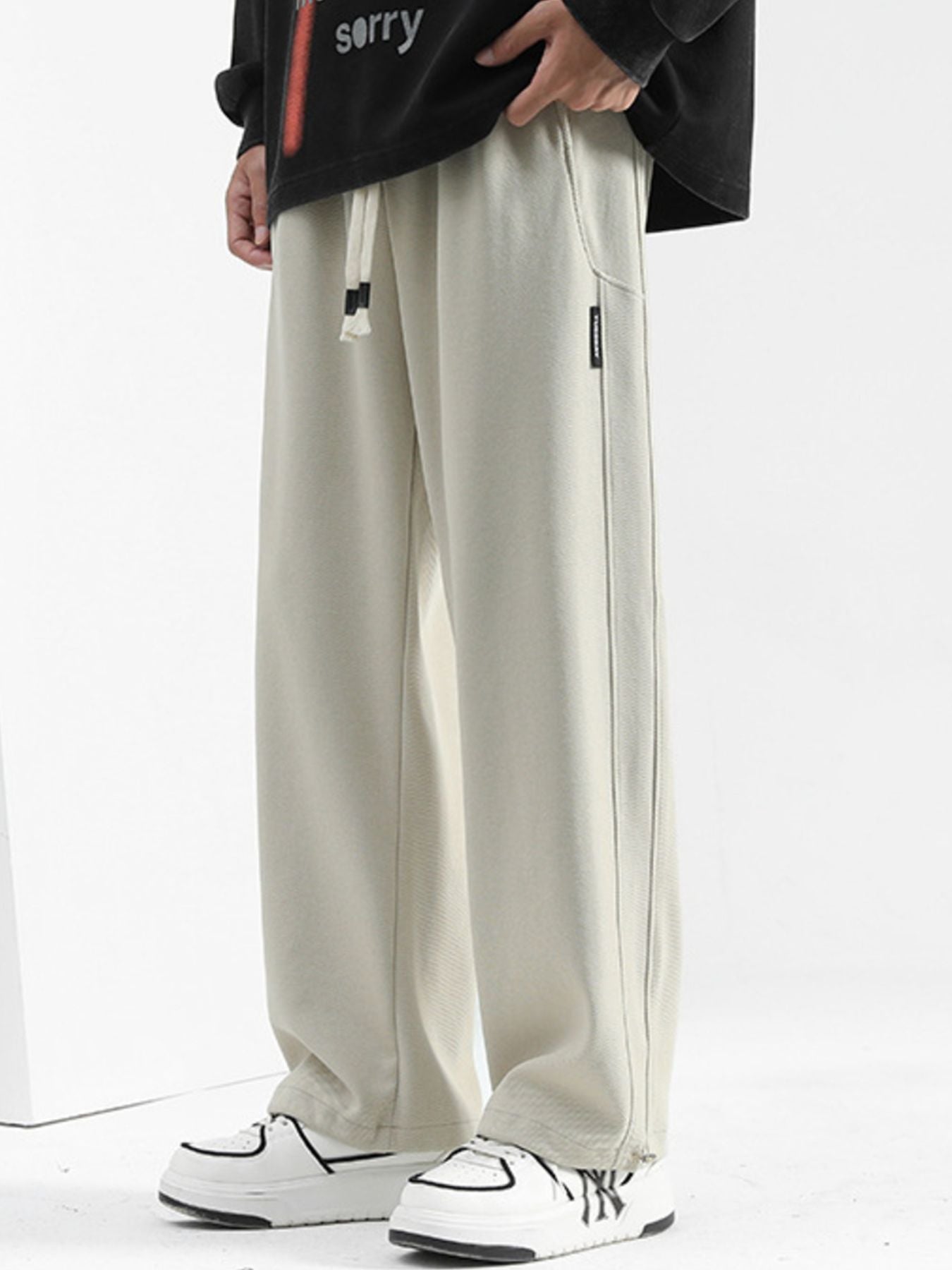 Men's beige casual loose-fit drawstring sweatpants with side seam detail.