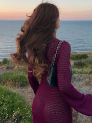 Plum purple knit maxi dress with bell sleeves and a sheer texture, worn with a black quilted bag.