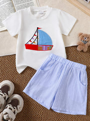 White baby tee with sailboat appliqué and blue striped shorts.