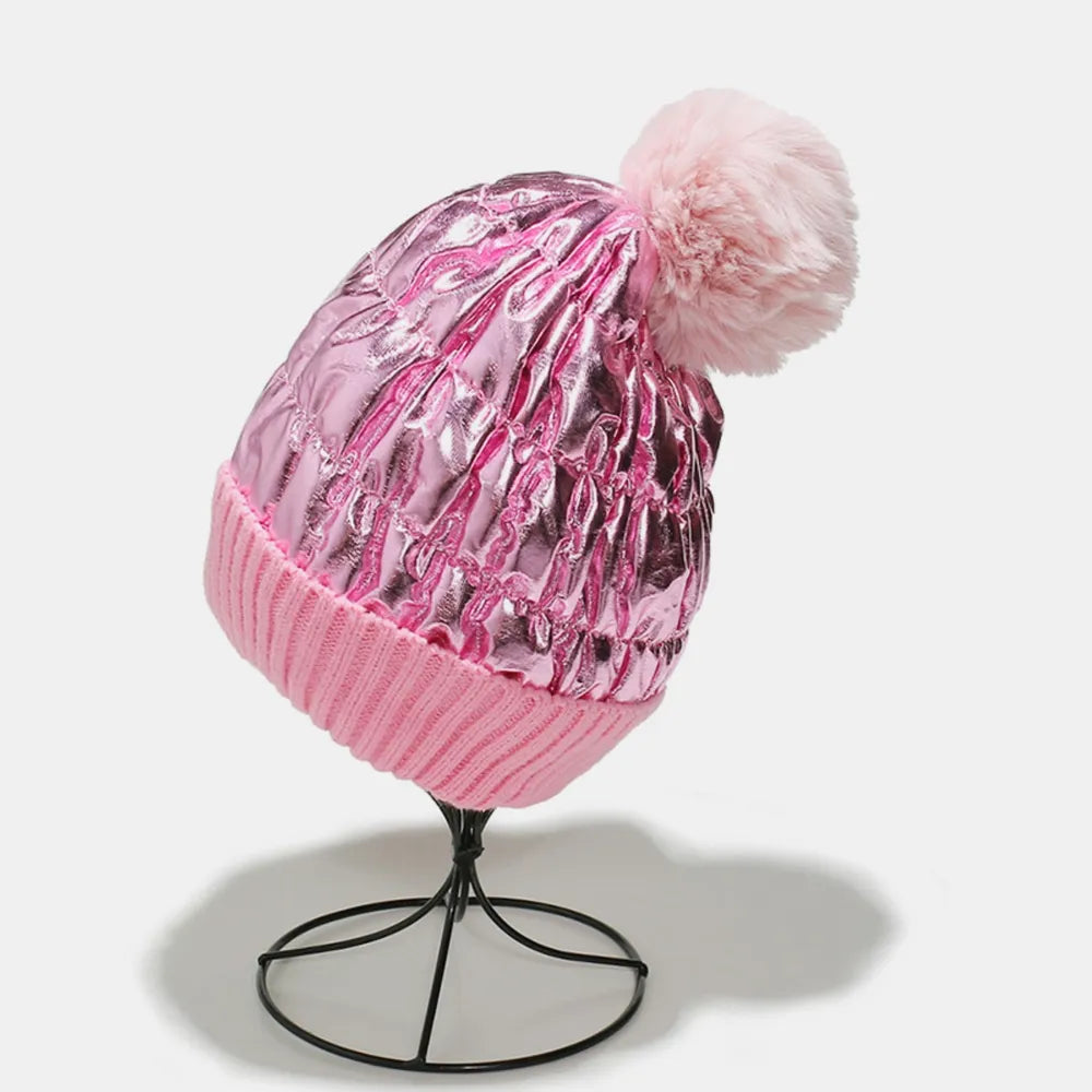 Pink metallic padded beanie with quilted texture and faux fur pom.