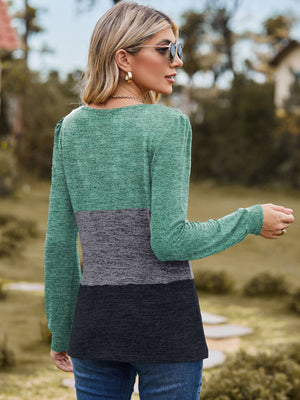 Blouson top with colorblock design in green, gray, and black, long sleeves, and crew neck.