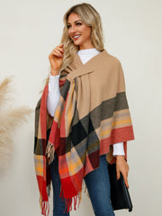 Asymmetric plaid fringe cape in tan with red, black, yellow, and grey checkered pattern.
