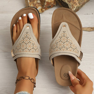 Beige hollow-out toe-post sandals with adjustable ankle strap and cork-style sole.
