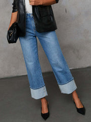Medium wash denim jeans with wide legs and cuffed hems.
