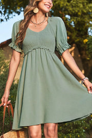Sage smocked V-neck mini dress with frill puff sleeves and tiered skirt.