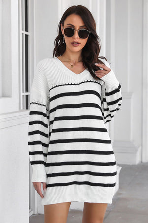 White and black striped knit mini dress with a V-neck and long sleeves.