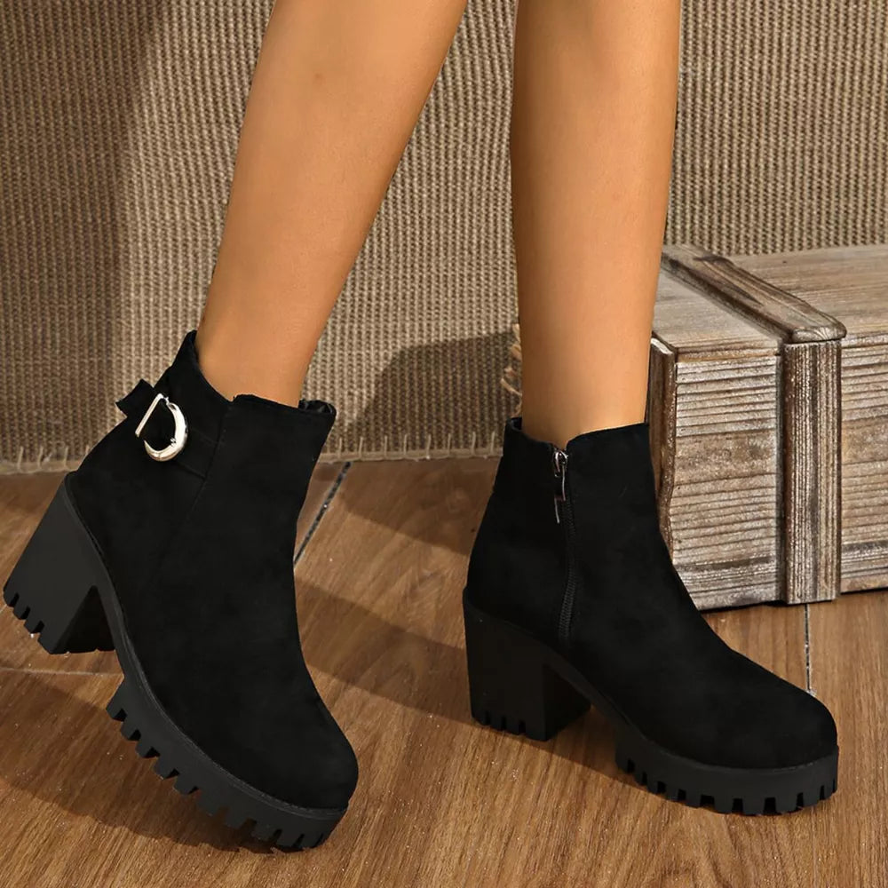 Black suede ankle boots with round toe, block heel, and decorative buckle detail.