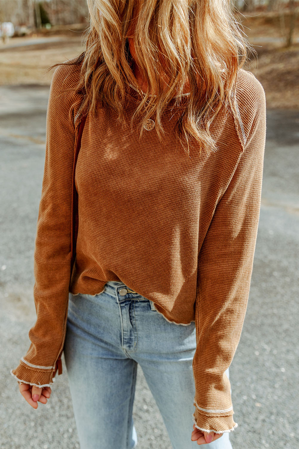 Caramel waffle knit raglan sweater with ruffled cuffs and raw hem detail.